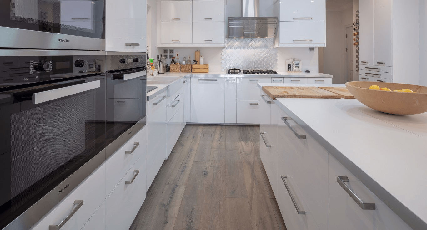 Kitchen flooring in a modern home in Dubai, with grey-toned wood floors that complement the clean interior by Nordic Homeworx.