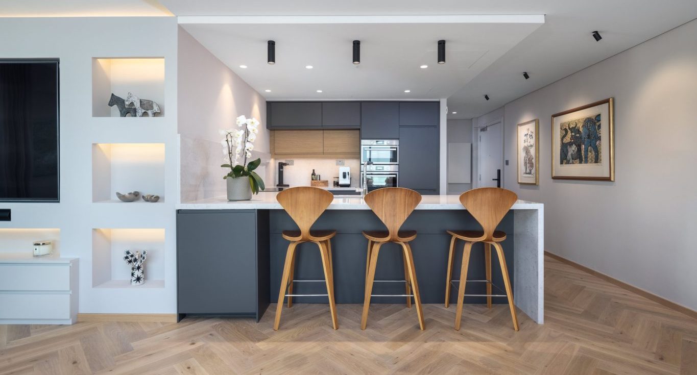 Herringbone oak flooring brings natural character to the bright kitchen and circulation spaces of this Fairways North apartment.