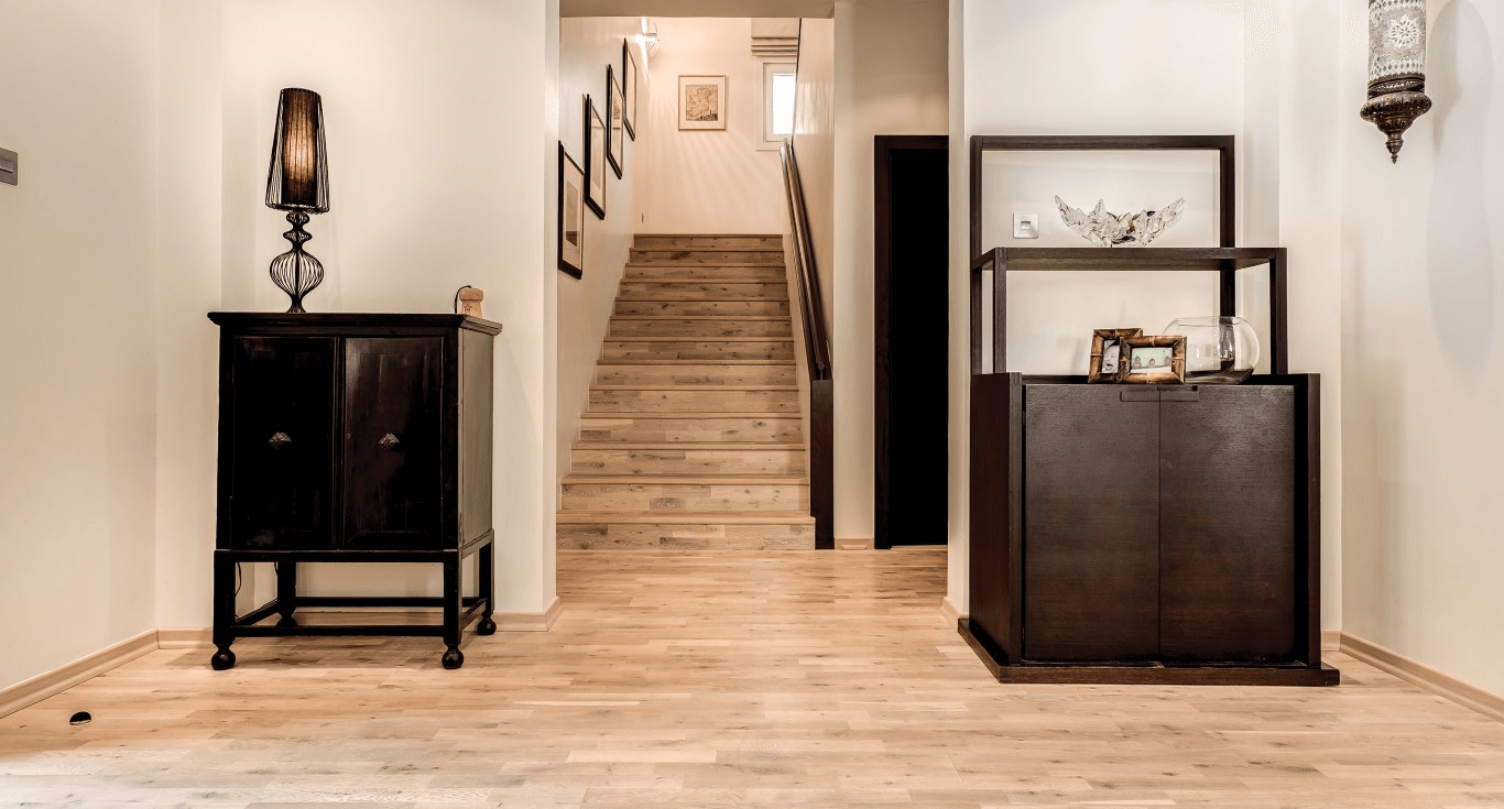 Elegant staircase inside Hattan Villa in Dubai, featuring a light wood floor texture that complements the spacious design.