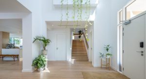  Interior of a Hattan Villa with a clean flooring material, white walls, greenery, a coffee bar, a staircase, and a wooden bench.