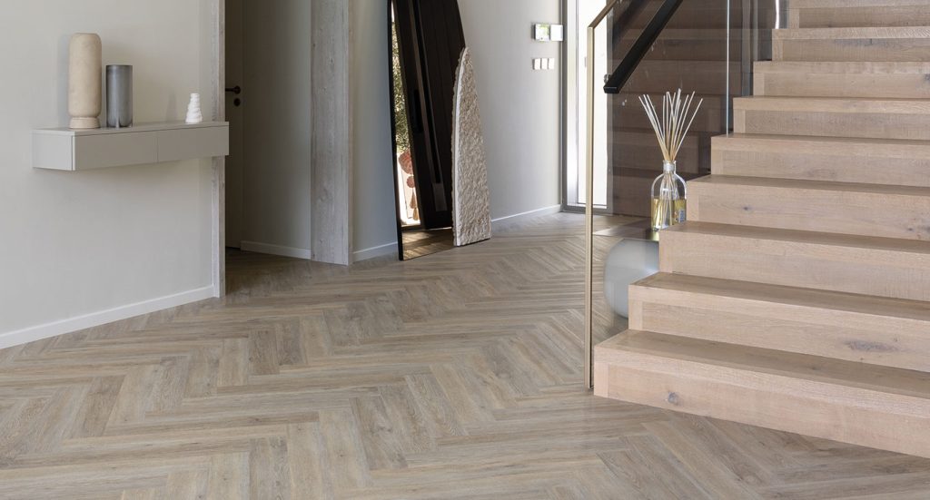 An entryway with premium flooring materials, a staircase, a wall shelf, and other decorations of a Golf Place Villa.