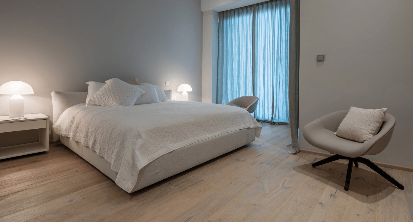 A cozy bedroom in Cayan Tower with damage-free wooden flooring