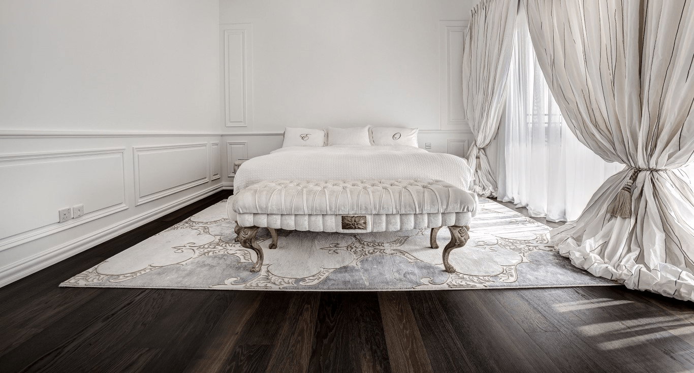 A bedroom from a family-type villa in Green Community DIP using light curtains for dark wood floors