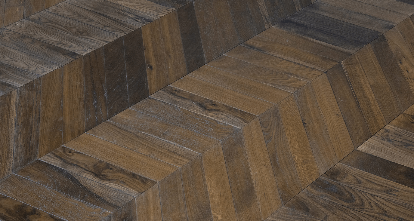Detailed parquet flooring restoration from Al Khawaneej Villa, featuring timeless smoked chevron flooring by Nordic Homeworx