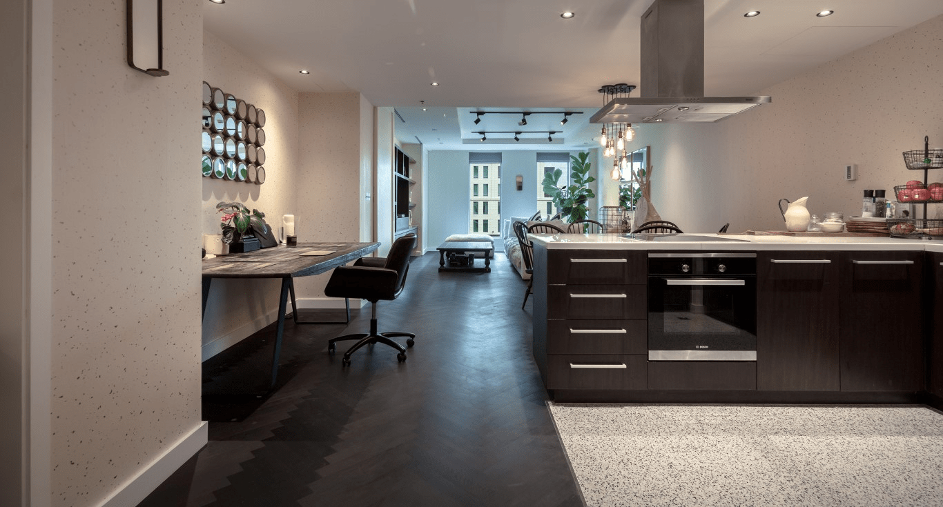 Open-plan kitchen and dining area in Limestone House, Dubai, featuring Smoked Oak Herringbone parquet flooring by Nordic Homeworx.