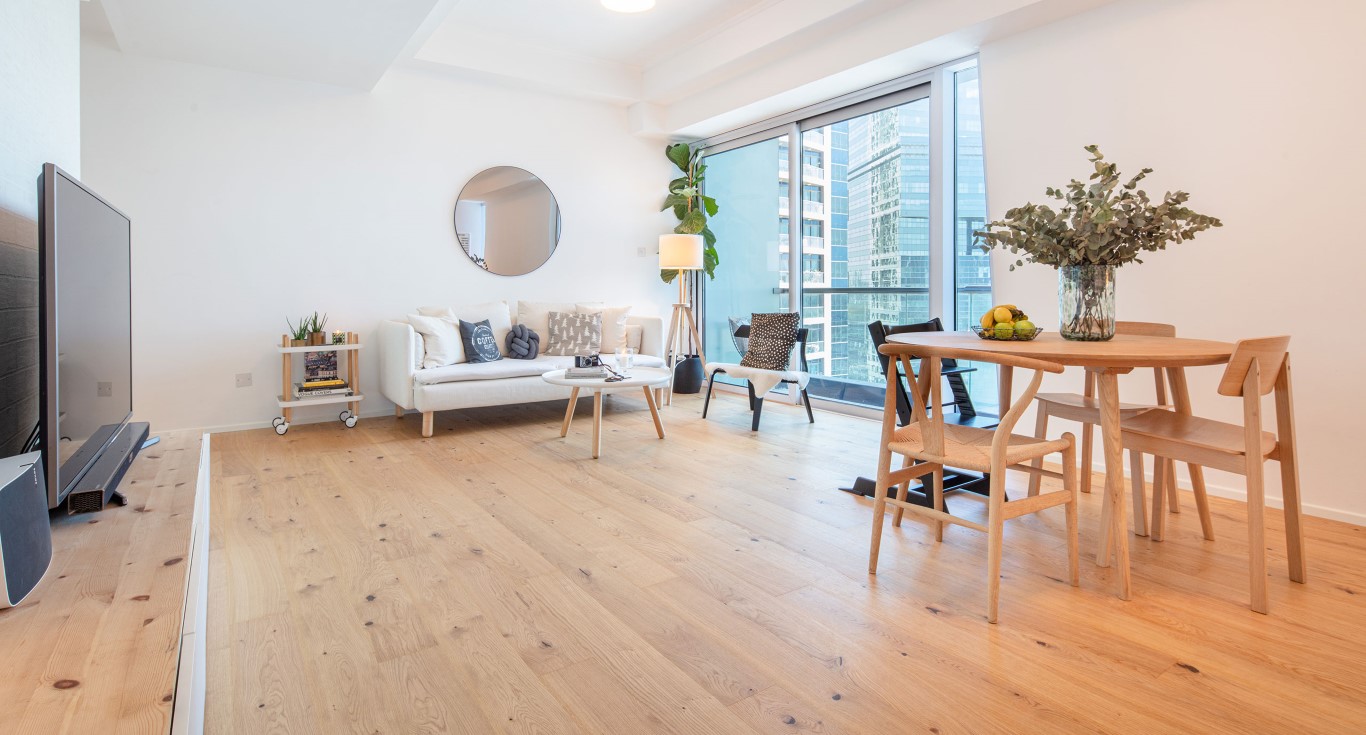 Rustic hardwood flooring introducing natural texture within this Scandinavian-inspired Goldcrest Views apartment.